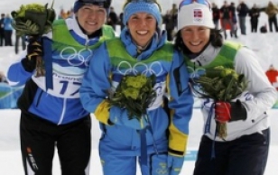 Sweden's Charlotte Kalla (centre), Norway's Marit Bjoergen (right) and Estonia's Kristina Smigun-Vaehi pose at the podium during the flower ceremony after their women's 10 km individual start cross-country final at the Vancouver Winter Olympic Games.