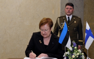 President of Finland, Mrs. Tarja Halonen signs the official guest book.